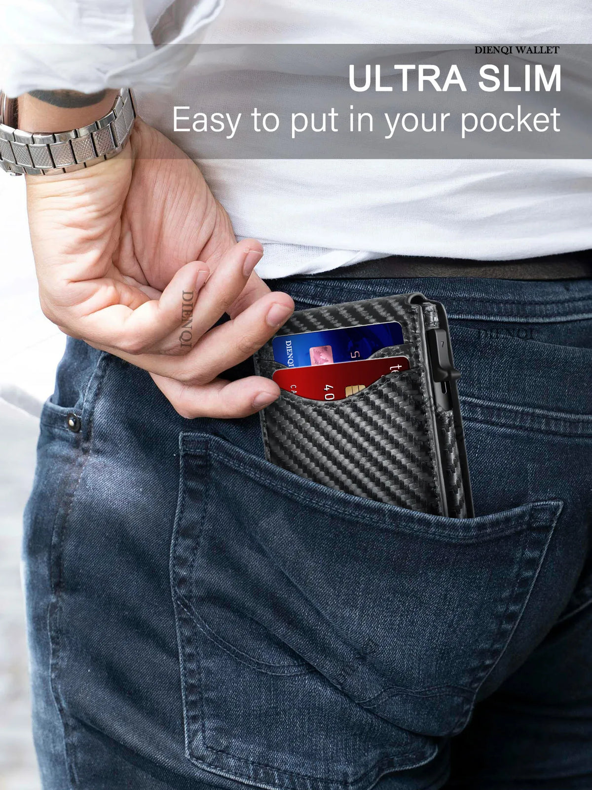 A hand places a black carbon fiber slim wallet into the pocket of dark blue jeans.