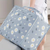 Light blue blanket storage bags featuring a white daisy pattern, shown next to a person.