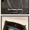 Nahaufnahme einer schwarzen Pailletten-Rhinestone-Schultertasche, die die Hardware und die interne Kapazität zeigt.