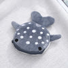 A gray shark mini plush coin purse wallet with white polka dots resting on a light fabric background.