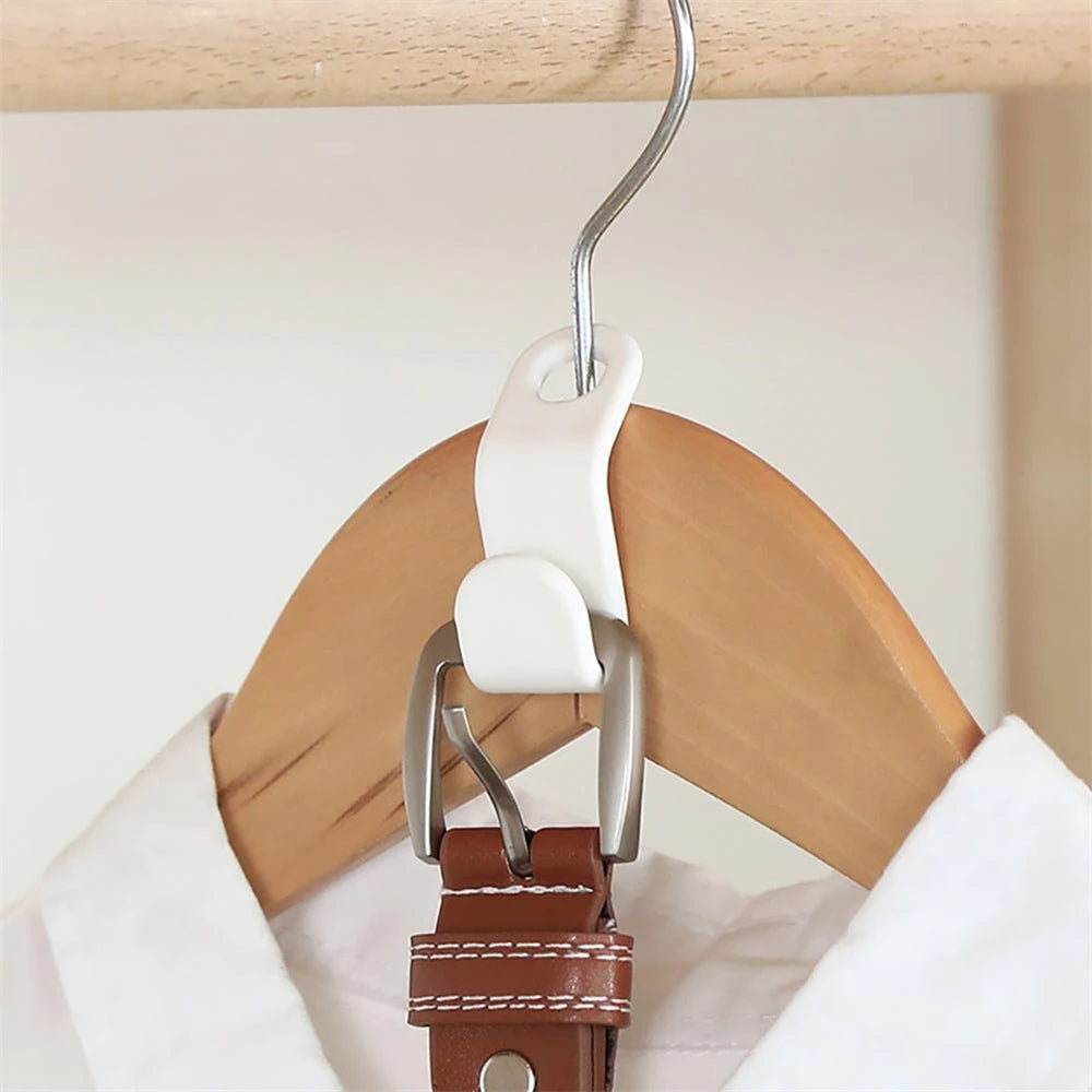 A multi-hook wardrobe organizer with a white plastic hanger and a brown leather strap hanging from it.