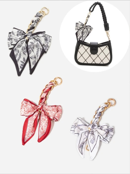 A collection of bow bag chain strap extensions featuring black and white floral patterns on leather and fabric.