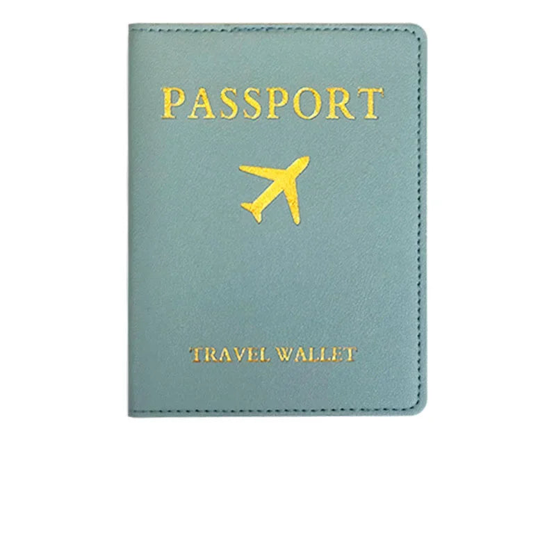 A light blue passport holder made of PU leather with gold lettering and an embroidered airplane symbol.