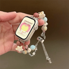 Eine Hand hält ein verstellbares Metallarmband mit verschiedenen Kristallperlen und einem Smartphone angebracht.