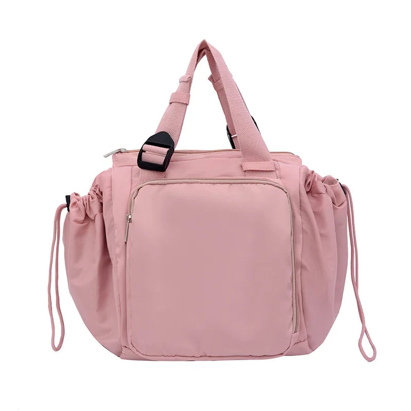 A pink nylon shoulder bag with adjustable straps and drawstring closure.