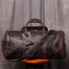Dunkelbraune Vintage-Leder-Totebag mit braunem Lederriemen auf Holzoberfläche.