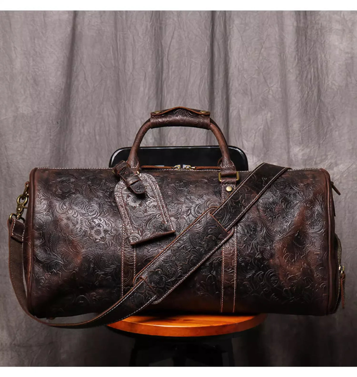 Dunkelbraune Vintage-Leder-Totebag mit braunem Lederriemen auf Holzoberfläche.