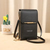 A black women's touch screen crossbody shoulder bag with gold hardware resting on a light surface.