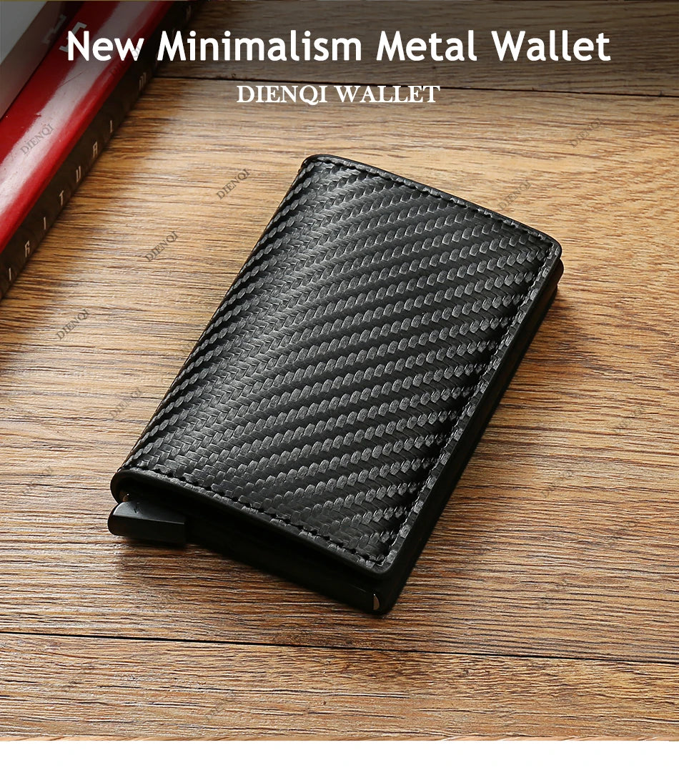 Portefeuille minimaliste en métal noir avec motif texturé posé sur une surface en bois.