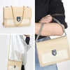 A beige leather shoulder bag with a stainless steel diamond-cut curb chain strap shown in various angles.