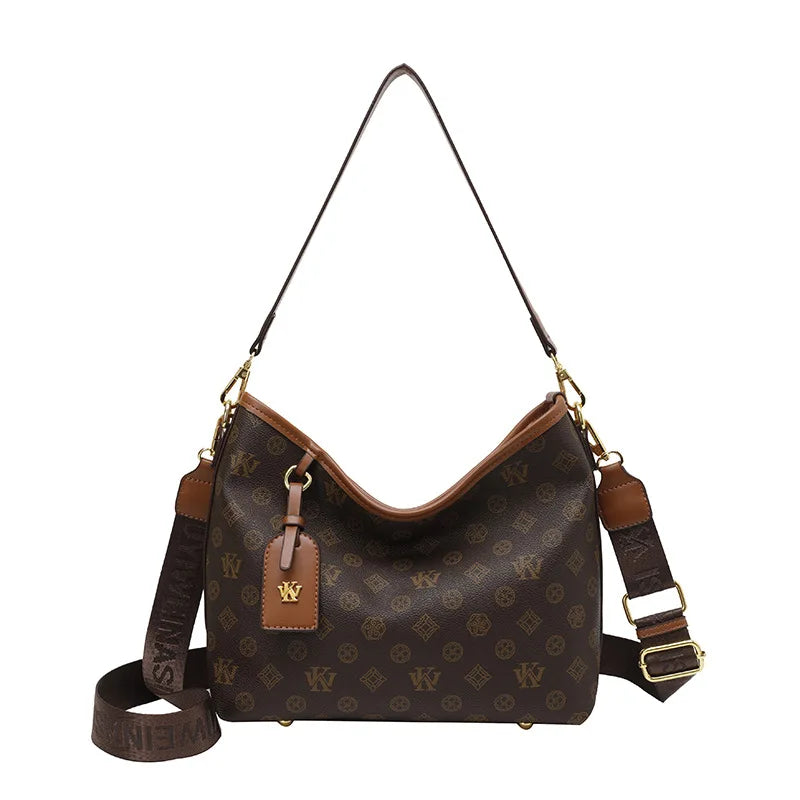 Brown leather crossbody tote bag with gold hardware and a repeating monogram pattern