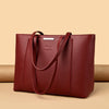 A deep burgundy leather shoulder bag with a smooth texture is displayed on a neutral background.