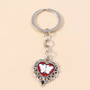 Silver heart-shaped keychain featuring a white butterfly pendant with red accents and intricate metalwork