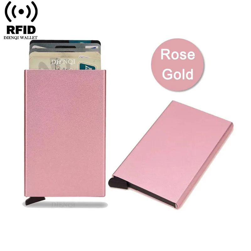 Una billetera delgada rosa RFID junto a una tarjeta dorada y una billetera rosa doblada.