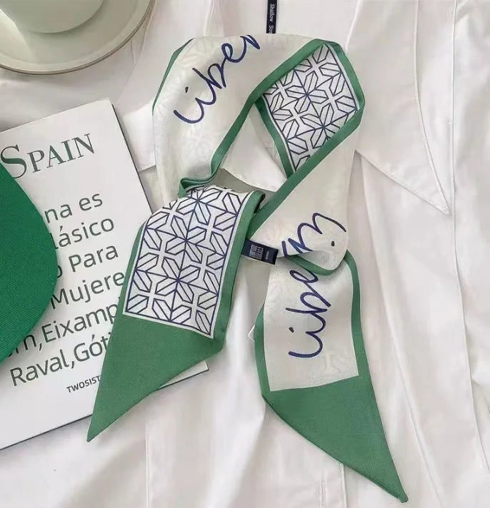 Un foulard pour les cheveux en soie vert et blanc, à côté d'un document sur l'Espagne.