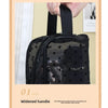 A black mesh transparent makeup storage bag with a widened handle is being held by a hand.