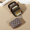 A brown zippered card holder wallet is open, displaying several stacks of US dollar bills and coins on a beige surface.