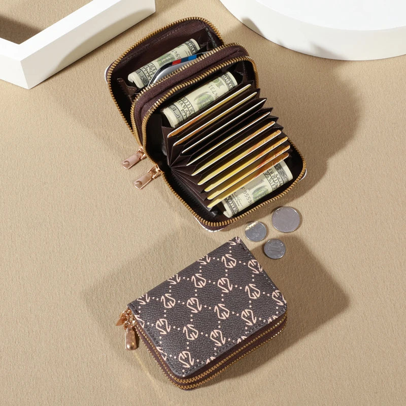 A brown zippered card holder wallet is open, displaying several stacks of US dollar bills and coins on a beige surface.