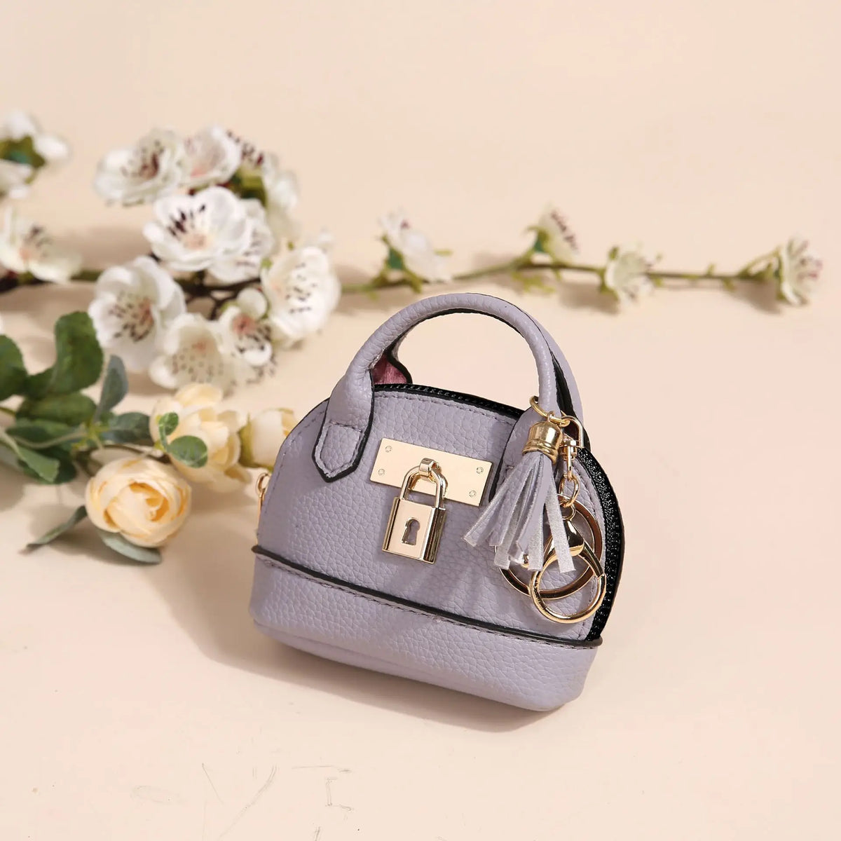 Portefeuille en PVC violet clair de luxe avec cadenas doré, suspendu à la sangle, sur fond doux