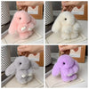 A collection of cute plush rabbit bag charms in pink, white, and gray colors displayed on a light surface.