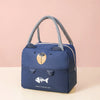 A navy blue insulated thermal picnic lunch bag with gray fabric handles and a gold fish emblem.