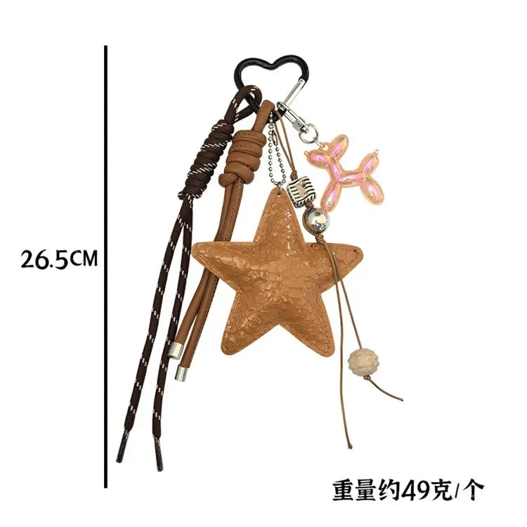 Clé portkey en forme d'étoile marron avec un charm de chien ballon rose et une corde en cuir.