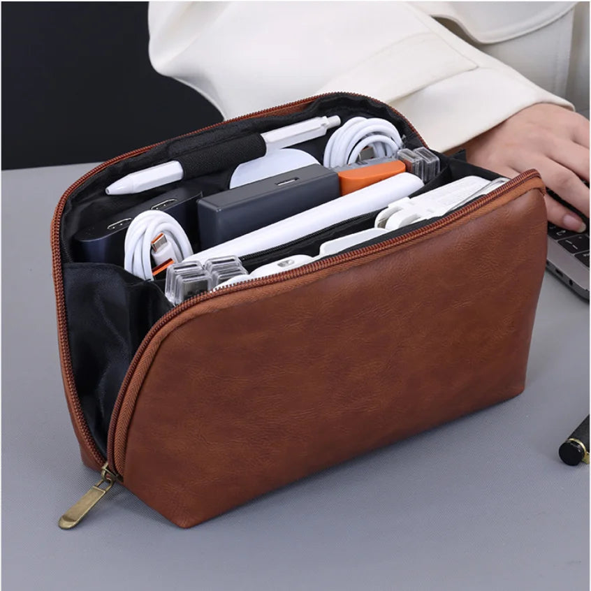 A brown leather multi-layer cable organizer pouch is shown open, displaying various white and black electronic cables and acc
