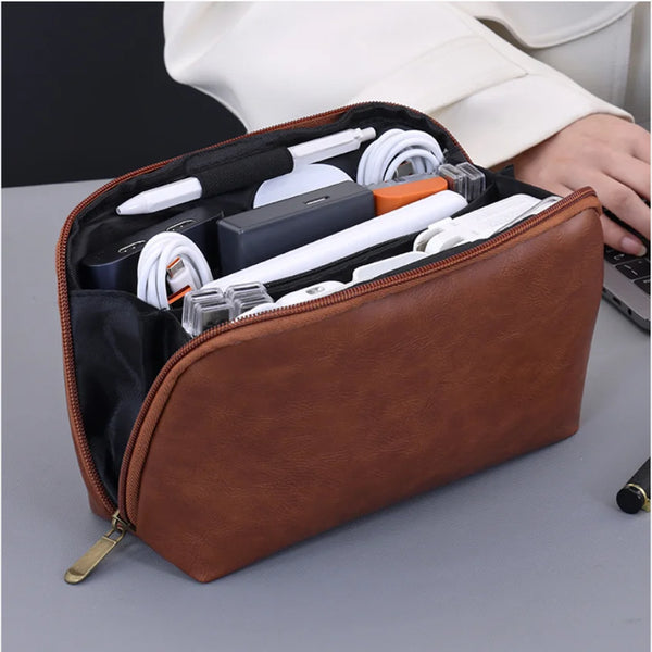 A brown leather multi-layer cable organizer pouch is shown open, displaying various white and black electronic cables and acc
