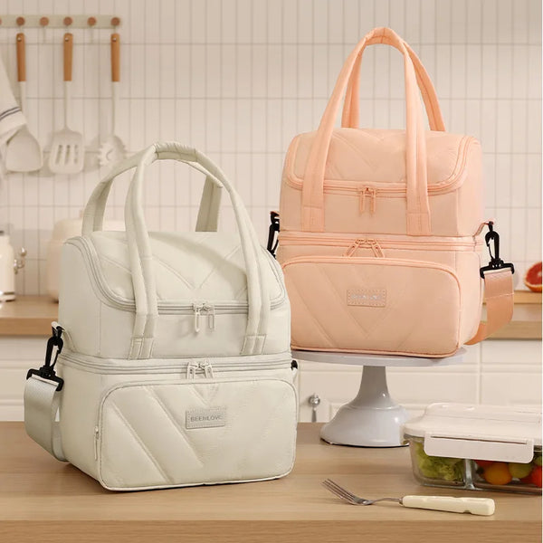 A pink and white double-layer insulated lunch bag is displayed on a stand.
