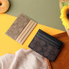 A stack of elegant PU leather card holders in beige and black textures resting on a wooden surface.