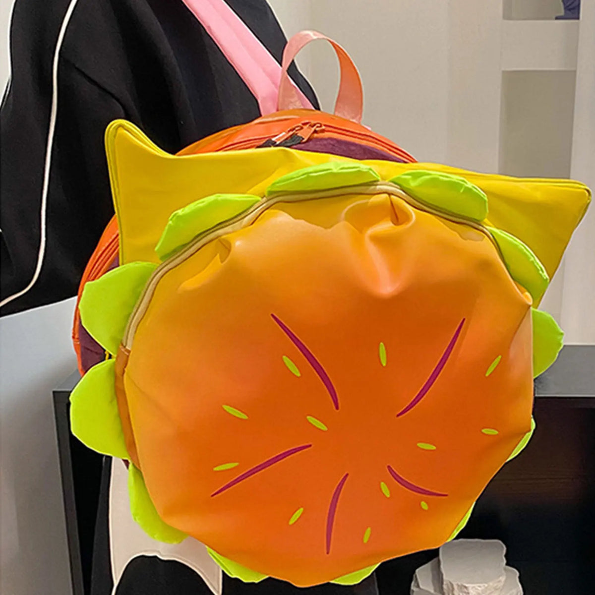 An orange and yellow novelty backpack shaped like a slice of watermelon.