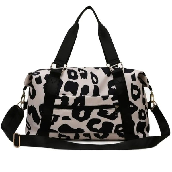 Sac de voyage en toile léopard beige et noir avec anses noires.
