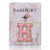 Una funda de pasaporte de imitación de cuero rosa claro con detalles dorados y un diseño de avión negro.