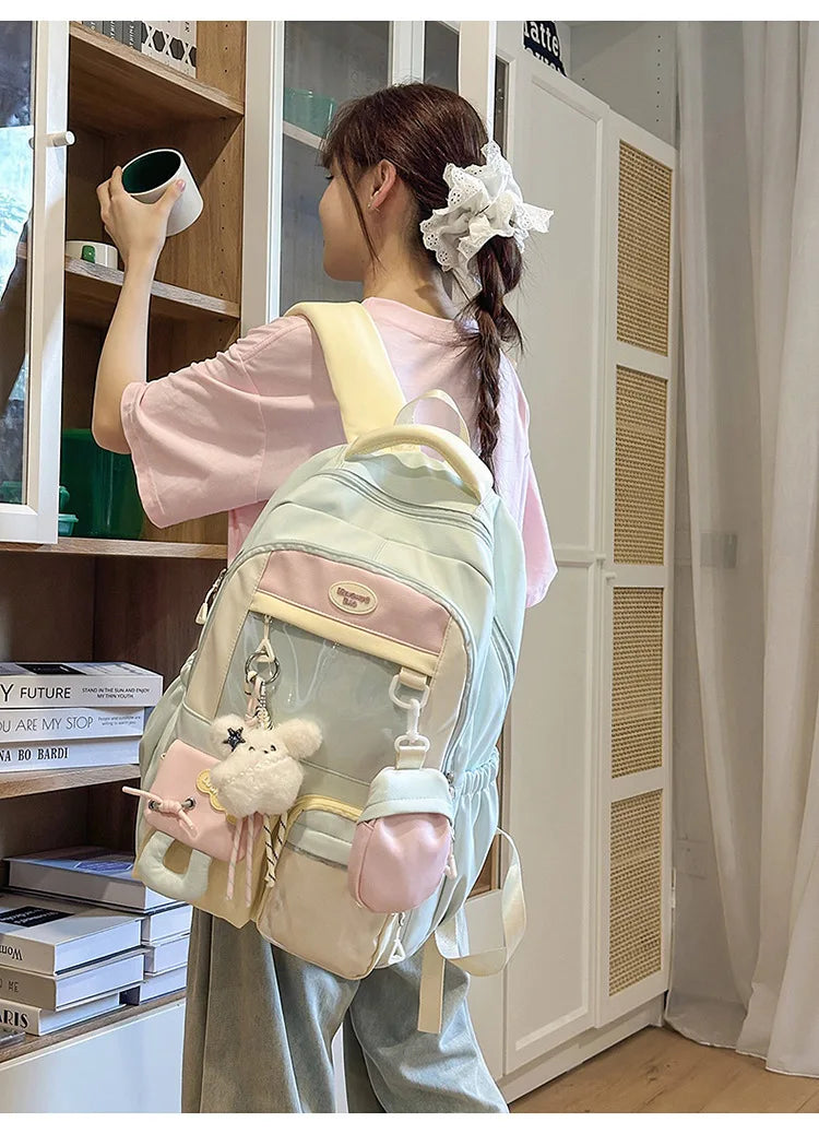 A young woman is wearing a light pink shirt and gray pants while carrying a pastel green Kawaii Harajuku backpack.