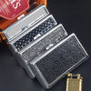 A silver metal cigarette case holder with textured surfaces is shown on a dark background.