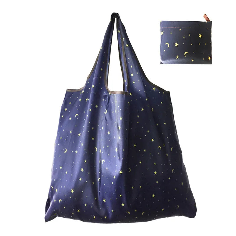 A dark blue nylon reusable tote bag featuring gold star patterns.
