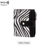 A black and white zebra striped compact wallet with a zippered closure and a coin pouch.