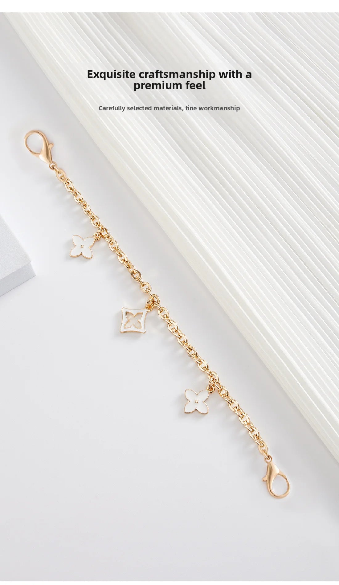 A delicate gold chain with small floral charms is displayed against a white background.