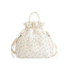 A cream-colored insulated waterproof lunch bag with a drawstring closure and a floral pattern.