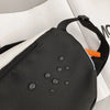 A black nylon chest rig bag with orange accents is shown on a white background.