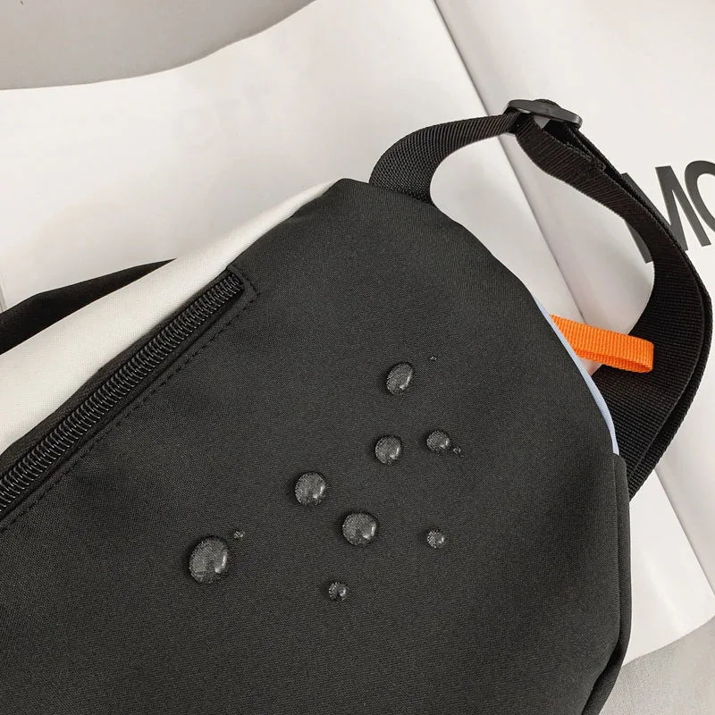 A black nylon chest rig bag with orange accents is shown on a white background.