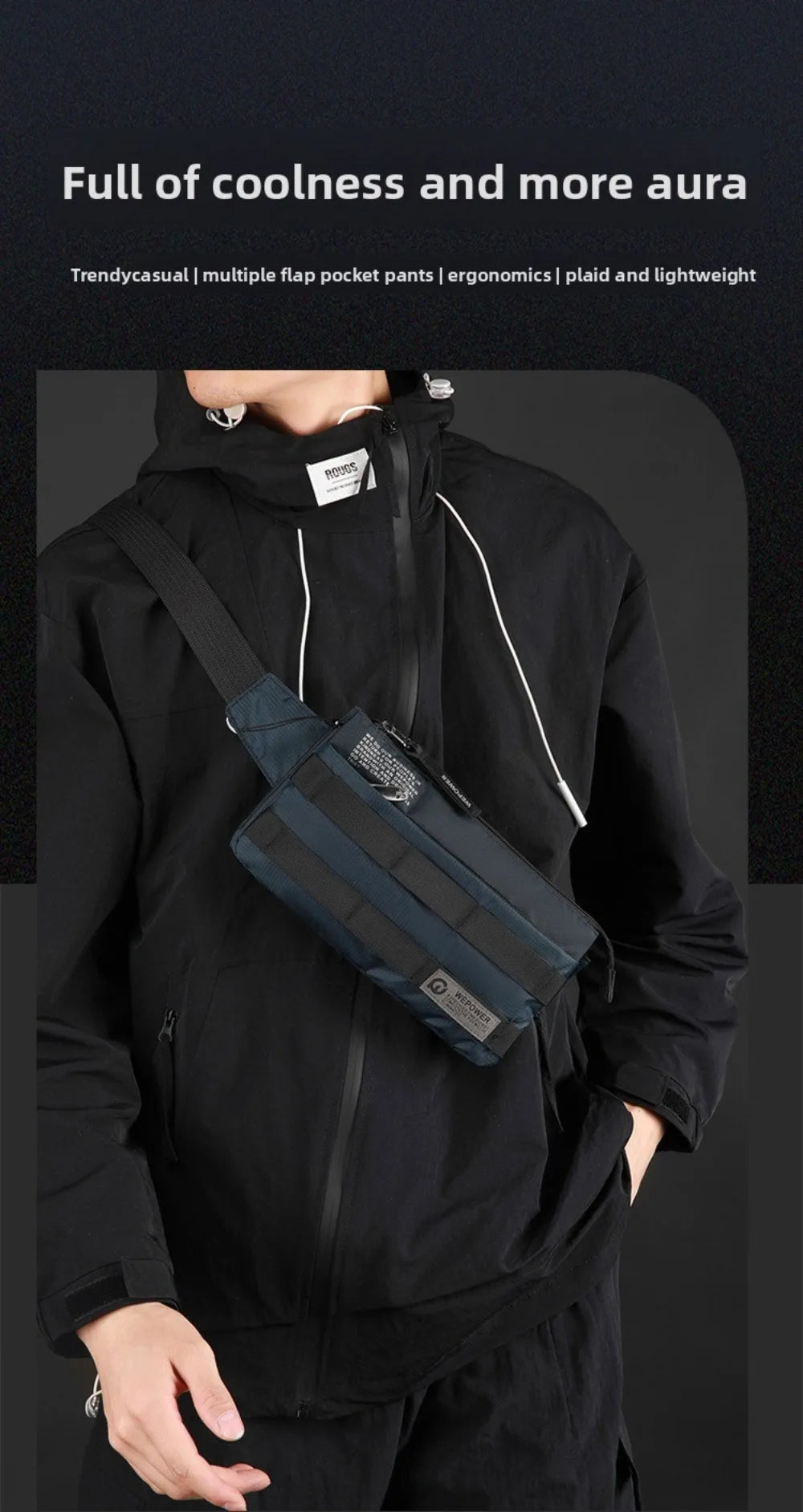 A person wearing a black hoodie holds a dark blue multifunctional chest bag across their chest.