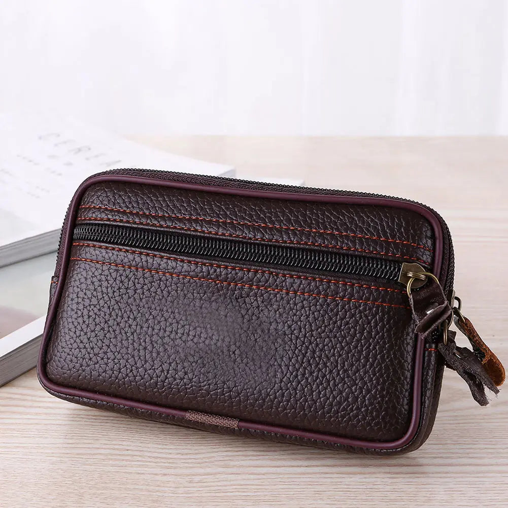 A dark brown PU leather waist bag with stitching and a gold-toned clasp resting on a light wooden surface.
