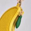 A yellow fruit-shaped PU leather coin purse keychain with a gold-toned clasp and a green zipper pull.