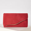 A vibrant red velvet evening clutch with a gold-toned detachable shoulder strap resting on a white surface.
