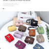 A collection of handcrafted leather neck pendant coin purses in various shades and colors displayed on a white table.