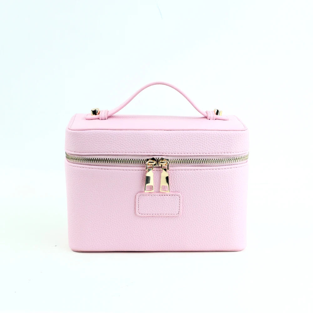 A pink PU leather makeup bag with a zipper and a loop handle.