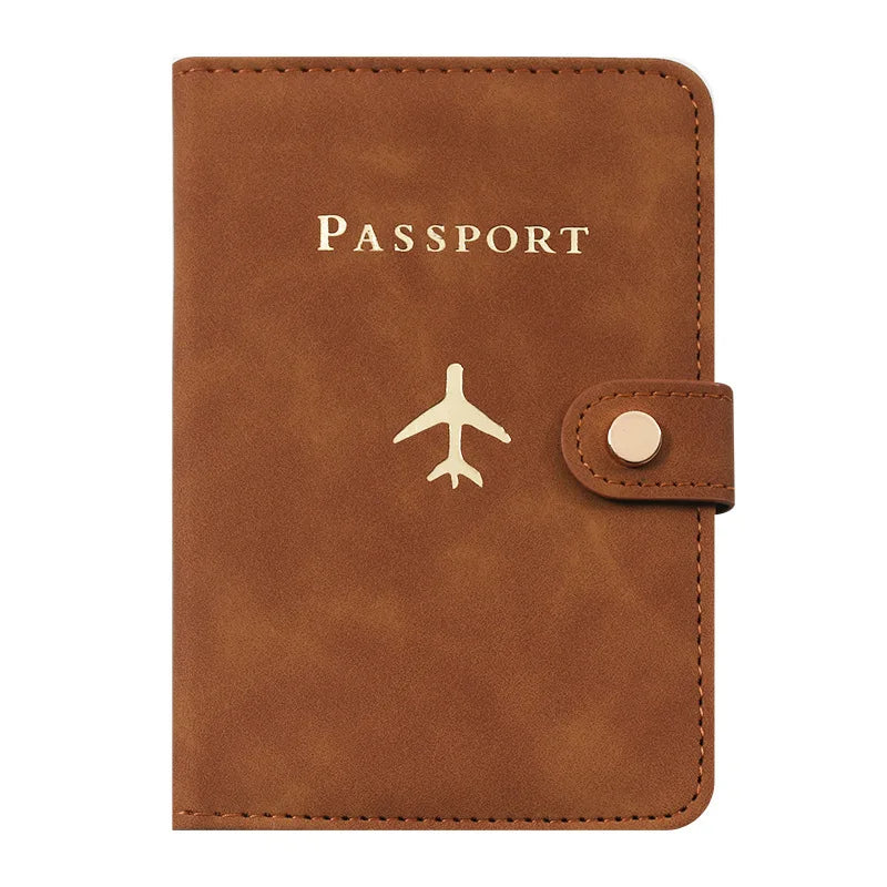 Porte-passeport en cuir marron avec le mot PASSPORT gravé et un petit logo d'avion.