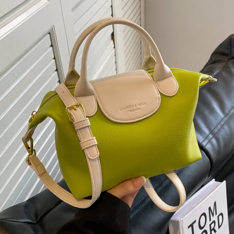 A lime green vintage PU leather crossbody handbag is held in a person's hand against a dark leather couch.