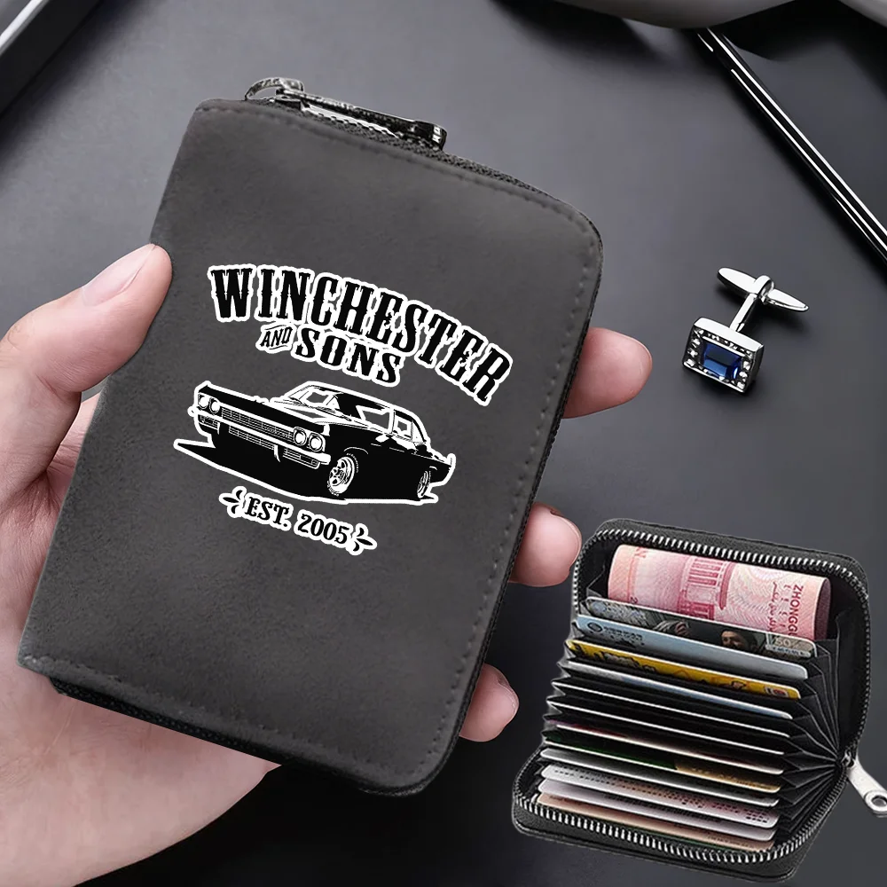 A dark gray leather card wallet with a silver clasp and a separate black card holder is shown being held by a hand.